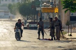 FILE - Rebel fighters man a checkpoint in Taybat al-Imam town after they advanced in the town in Hama province, Syria, Aug. 31, 2016.