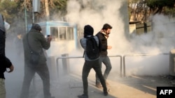 Iranian students run for cover from tear gas at the University of Tehran during a demonstration driven by anger over economic problems, in the capital Tehran, Iran, Dec. 30, 2017. 