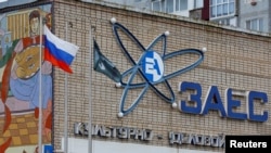 Російський прапор вивішений біля культурно-ділового центру з логотипом Запорізької атомної електростанції в місті Енергодар Запорізької області, окупованому росіїйськими військами. Україна, 24 листопада, 2022 року. REUTERS/Олександр Єрмоченко