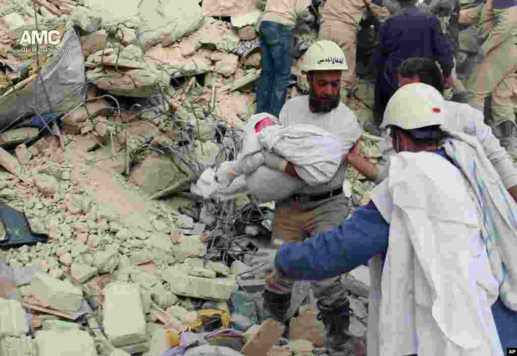 Civil defense rescue workers carrying the body of a victim of a Syrian government airstrike, Aleppo, April 6, 2014. &nbsp;