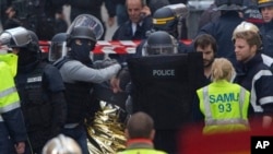 Hooded police officers detain a man in Saint-Denis, near Paris, Nov. 18, 2015.