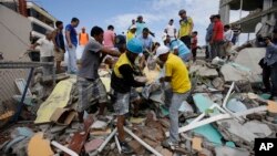Volunteers rescue a body from a destroyed house after a massive earthquake in Pedernales, Ecuador, April 17, 2016. 