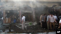 Warga setempat memeriksa lokasi sekitar meledaknya sepeda motor di dekat sebuah toko senjata di Kirkuk, 290 kilometer dari Baghdad, Irak (19/9).