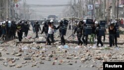 រូបឯកសារ៖ កម្មករ​ត្រូវ​បាន​ចាប់ឃុំ​ខ្លួន​ដោយ​នគរបាល​បង្ក្រាប​កុបកម្ម ក្រោយពី​មាន​ការប៉ះទង្គិច​គ្នា​នៅក្នុង​បាតុកម្ម​មួយ​ក្នុង​ទីក្រុង​ភ្នំពេញ នៅ​ថ្ងៃទី៣ ខែមករា ឆ្នាំ២០១៤។ (រូបថត៖ Reuters)