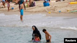 یک زن مسلمان در ساحل فرانسه با بورکینی یا حجاب اسلامی