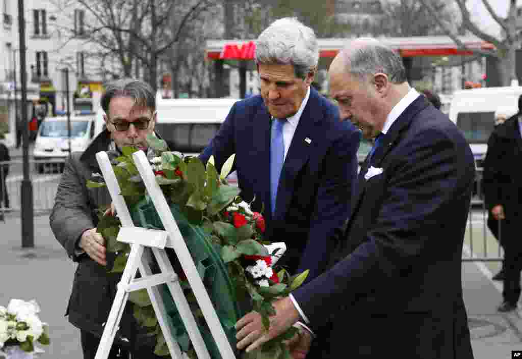 U.S. Secretary of State John Kerry lays a wreath with French Foreign Minister Laurent Fabius at the site of one of the terrorist attacks, the Hyper Cacher kosher market, in Paris, Jan. 16, 2015.