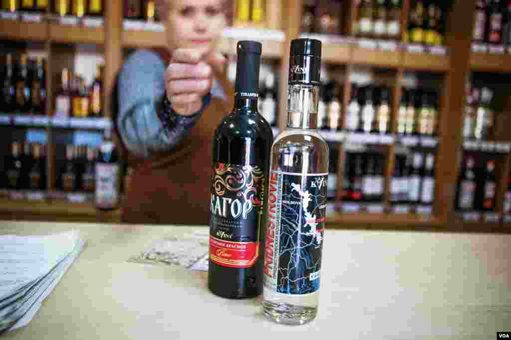 At a Kvint store, a saleswoman shows a vodka bottle with a label outlining Transniester's stringbean shape. (Vera Undritz for VOA)