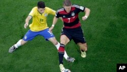 Brazil's Oscar (L) and Germany's Bastian Schweinsteiger vie for the ball during the World Cup semifinal soccer match between Brazil and Germany at Mineirao Stadium in Belo Horizonte, Brazil, July 8, 2014.