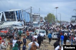 Warga Palestina membawa karung-karung berisi tepung yang mereka ambil dari truk bantuan di dekat pos pemeriksaan Israel di tengah krisis kelaparan, di Kota Gaza, Sabtu, 27 Januari 2024. (Foto: Hossam Azam/Reuters)