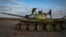 Ukrainian soldiers inspect a damaged Russian tank in the recently retaken village Chornobaivka near Kherson, Ukraine, Tuesday, Nov. 15, 2022. (AP Photo/Efrem Lukatsky)