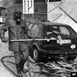 A 1986 file photo shows firefighters in protective gear washing a West German car near Herleshausen at the East German border after it arrived from Poland bearing radioactive fallout from the Chernobyl nuclear plant disaster