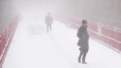 People make their way over the Williamsburg bridge during a snow storm, Jan. 29, 2022, in New York.