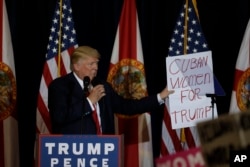 Republican presidential candidate Donald Trump holds a placard during a campaign speech in Tampa, Fla., Nov. 5, 2016.