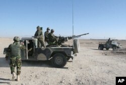 Afghan National Army soldiers guard at a checkpoint on the way to the Sangin district of Helmand province, Afghanistan, Wednesday, Dec. 23, 2015.