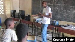 RENAMA employee Mayamiko Minofu explains portable solar-powered battery boxes and other rental products to rural customers. (VOA/Lameck Masina)