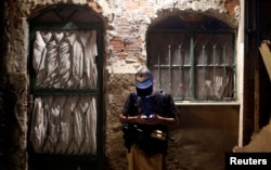 A Brazilian drug gang member checks his mobile phone in a slum in Rio de Janeiro, Brazil, March 19, 2018.