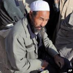 A painter eats his breakfast at Kote Sangi, an intersection in Kabul where hundreds of laborers wait daily to be hired for work