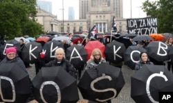 Women holding umbrellas march through downtown Warsaw to protest efforts by the nation's conservative leaders to tighten Poland's already restrictive abortion law, Oct. 3, 2017.