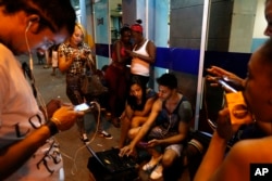 People surf the Internet at a public Wi-Fi hotspot in downtown Havana, Cuba, March 16, 2016.