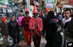 Iranian youths, wearing red clothes and black makeup as a symbol of the Iranian New Year, sing and play tambourine at Tajrish square in northern Tehran, Iran, ahead of the Iranian New Year, or Nowruz, meaning "new day," March 18, 2017.