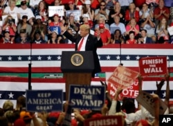 President Donald Trump reacts as supporters wave signs during a rally, Oct. 31, 2018, in Estero, Florida.