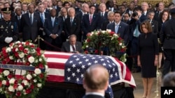 Speaker of the House Paul Ryan, center, and House minority leader Nancy Pelosi, right, pay their respects before the flag-draped coffin holding the remains of Sen. John McCain, Aug. 31, 2018, at the U.S. Capitol in Washington.