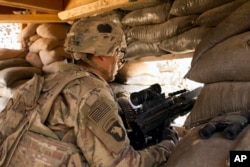 In this Sept. 8, 2016 photo, a U.S. Army soldier guards a position at Camp Swift, northern Iraq. U.S. troops will be engaged more closely than ever in fighting against Islamic State group militants as they back Iraqi forces in the long-anticipated assault on Mosul.