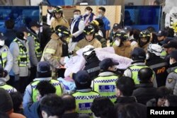 FILE - Firefighters rescue a patient from a burnt hospital in Miryang, South Korea, Jan. 26, 2018.
