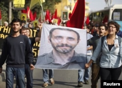 FILE - Students carry a portrait of Nejat Agirnasli, a People's Protection Unit (YPG) fighter who was killed during clashes with Islamic State militants in Kobani, during ceremony held in his memory at Bosphorus University in Istanbul, Oct. 17, 2014.
