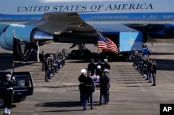 The flag-draped casket of former President George H.W. Bush is carried by a joint services military honor guard to Special Air Mission 41 at Ellington Field during a departure ceremony Monday, Dec. 3, 2018, in Houston, Texas.