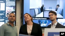 FILE – Facebook's Samidh Chakrabarti, director of elections and civic engagement, from left, stands with Katie Harbath, global politics and government outreach director, and Nathaniel Gleicher, head of cybersecurity policy, during a demonstration in the company's war room, where election-related content is monitored, in Menlo Park, Calif., Oct. 17, 2018.