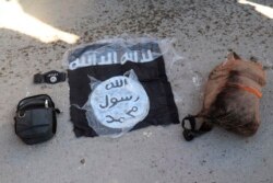 Bendera dan tas para pejuang ISIS yang ditangkap oleh Pasukan Demokratik Suriah pimpinan Kurdi pasca serangan di Penjara Gweiran, Hassakeh, timurlaut Suriah, 21 Januari 2022. (Pasukan Demokratik Suriah pimpinan Kurdi via AP)