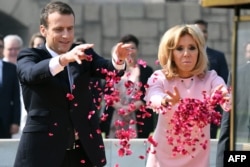 Presiden Perancis Emmanuel Macron dan istrinya Brigitte Macron menaburkan bunga di tugu peringatan Rajghat untuk menghormati Mahatma Gandhi di New Delhi, 10 Maret 2018.