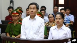 Vietnamese prominent blogger Nguyen Huu Vinh, left, and his colleague Nguyen Thi Minh Thuy stand trial at the Higher People’s Court in Hanoi, Vietnam, Thursday, Sept. 22, 2016.