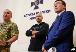 Russian journalist Arkady Babchenko, center, Vasily Hrytsak, head of the Ukrainian Security Service, left, and Ukrainian Prosecutor General Yuriy Lutsenko attend a news conference at Ukrainian Security Service headquarters in Kyiv, Ukraine, May 30, 2018.
