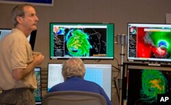 VD direktora Nacionalnog centra za uragane, Ed Rapaport, levo i viši specijalista za uragane Ričard Paš posmatraju na monitorima uragan Irmu u Nacionalnom centru za uragane u Majamiju, 10. septembra 2017.