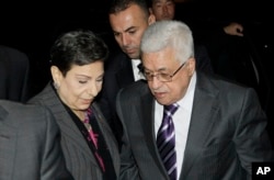 Palestinian President Mahmoud Abbas, right, is greeted by Hanan Ashrawi, left, legislator and activist, as he arrives at his hotel in New York, Monday, Sept. 19, 2011, to attend the 66th General Assembly session of United Nations.