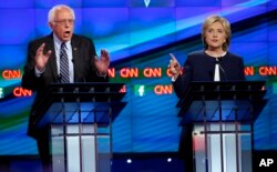 Democratic presidential candidate U.S. Senator Bernie Sanders (L) debates former Secretary of State Hillary Clinton during the first official Democratic candidates debate of the 2016 presidential campaign in Las Vegas, Nevada October 13, 2015.