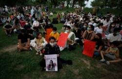 "Seorang aktivis hak-hak perempuan meletakkan lilin di samping poster bergambar Noor Mukadam, yang baru-baru ini dipenggal, untuk memberi penghormatan kepada Noor dan korban kekerasan dalam rumah tangga lainnya, di Islamabad, Pakistan. (Foto: AP)