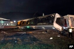 In this photo released by Taiwan Railways Administration, train carriages are scattered at the site of a train derailment in Yilan county northeastern Taiwan on Sunday, Oct. 21, 2018.