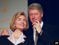 FILE - In this June 22, 1994 file photo, President Bill Clinton and first lady Hillary Clinton wait to address a group of young Democratic supporters known as the Saxophone Club in Washington.