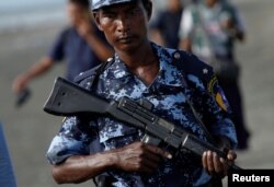 FILE - Myanmar border guards patrol near the Myanmar-Bangladeshi border outside Maungdaw, northern Rakhine state, Myanmar, Nov. 12, 2017.