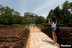 A tourist take pictures of the UNESCO listed World Heritage Site Sigiriya Rock Fortress in Sigiriya, Sri Lanka October 11, 2018. REUTERS/Dinuka Liyanawatte