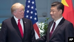 FILE - U.S. President Donald Trump, left, and Chinese President Xi Jinping arrive for a meeting on the sidelines of the G-20 Summit in Hamburg, Germany.