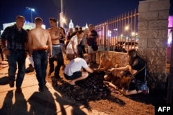People tend to the wounded outside the Route 91 Harvest Country music festival grounds after an apparent shooting on Oct. 1, 2017 in Las Vegas, Nevada.
