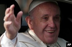 Pope Francis waves as he arrives at the San Luis Beltran church on his way to the Apostolic Nunciature in Santiago, Chile, Jan. 15, 2018.