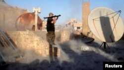 FILE - An American volunteer fighter of Syrian Democratic Forces fires an RPG during a battle with Islamic State militants in Raqqa, Syria, Oct. 6, 2017.