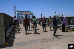 Protesters walk toward the sit-in protest outside the Sudanese military headquarters, in Khartoum, Sudan, May 14, 2019.