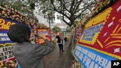 Seorang perempuan mengambil foto karangan bunga yang berupa ucapan dari para pendukung Gubernur DKI Jakarta, Basuki Tjahaja Purnama atau Ahok (26/4).