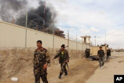 FILE - Smoke rises from a building where Taliban insurgents hid during a fight with Afghan security forces in Helmand province, Afghanistan, March 9, 2016.